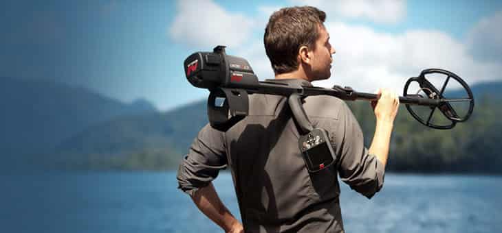 Man holds Metal Detector over his shoulder